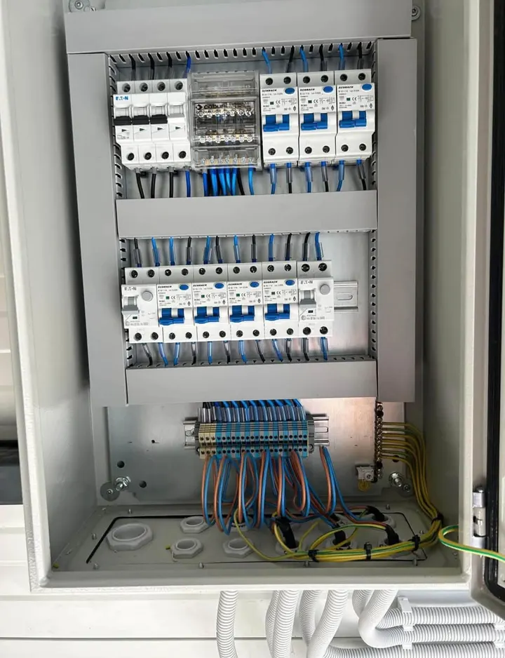 Tablou electric deschis, cu aparate de protecție, un distribuitor și cabluri legate pe cleme
