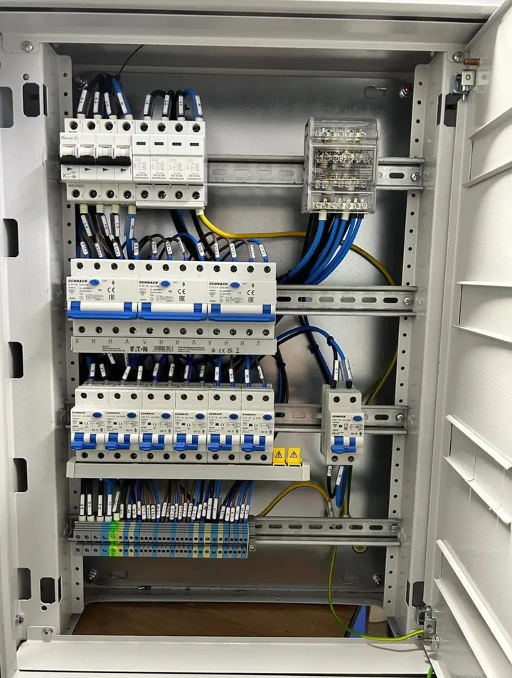 Tablou electric într-un dulap metalic, cu aparate de protecție pe șină și cabluri marcate cu etichete